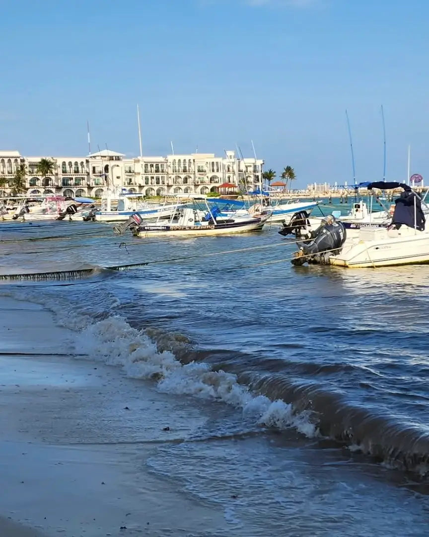 lanchas amarradas y hoteles de fondo en playa pelicanos
